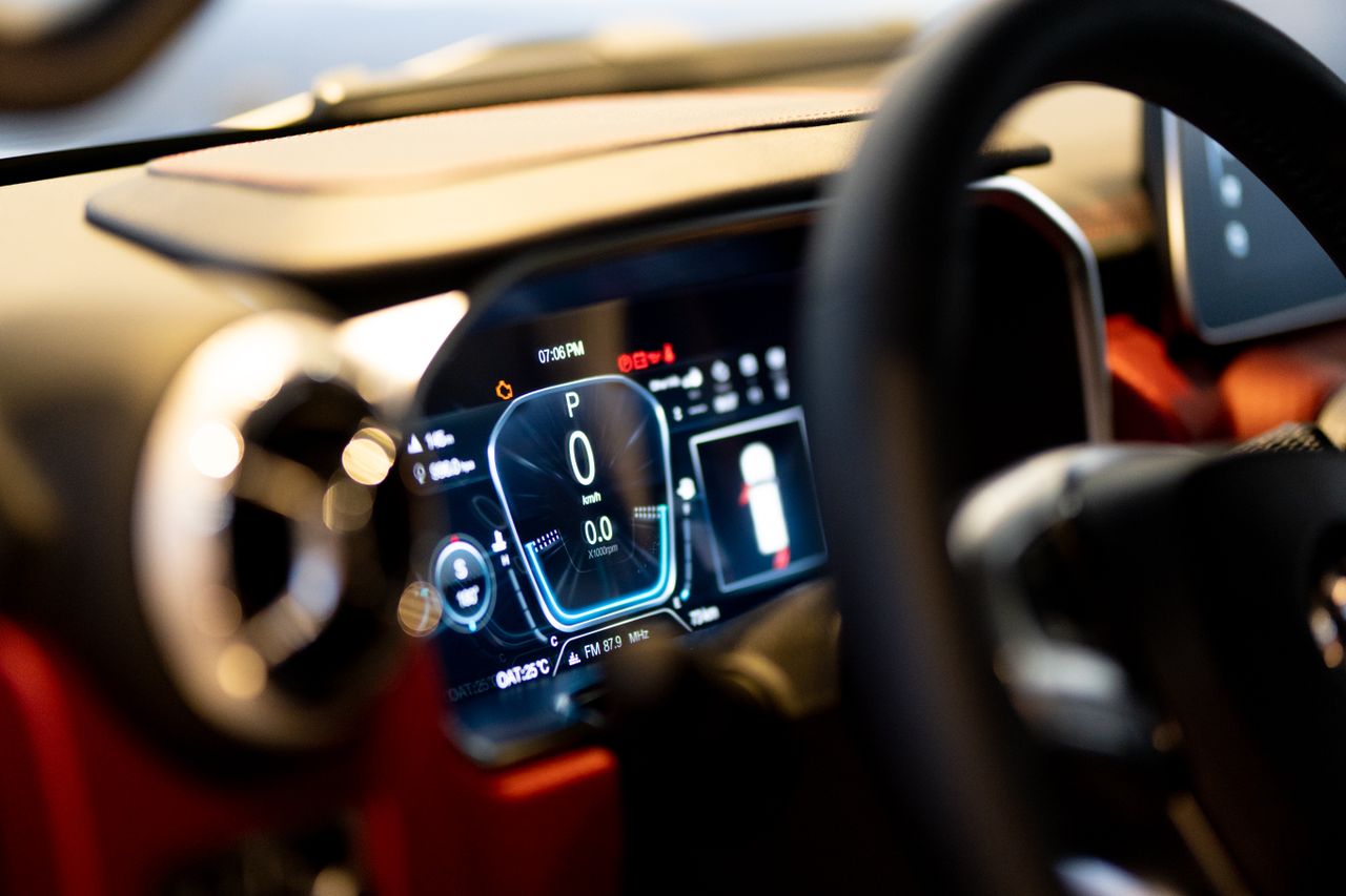 team-01 Close-up of illuminated car dashboard interior showing digital displays in Dubai showroom.